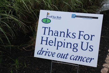 sign in the grass that reads thanks for helping us drive out cancer